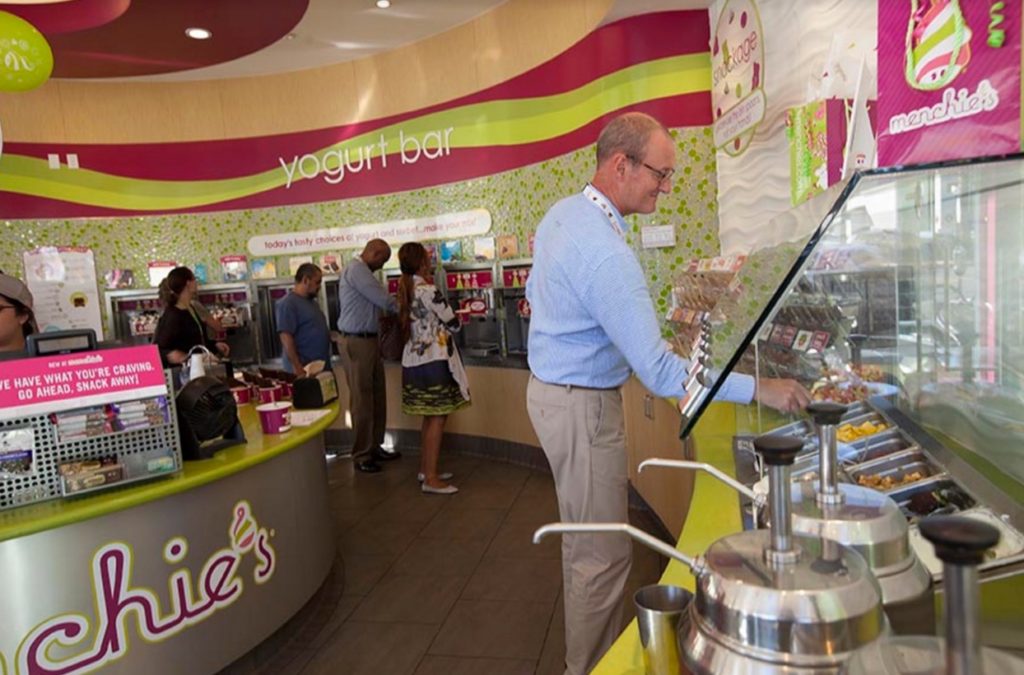 Guests help themselves to frozen yogurt and toppings inside a Menchie's.